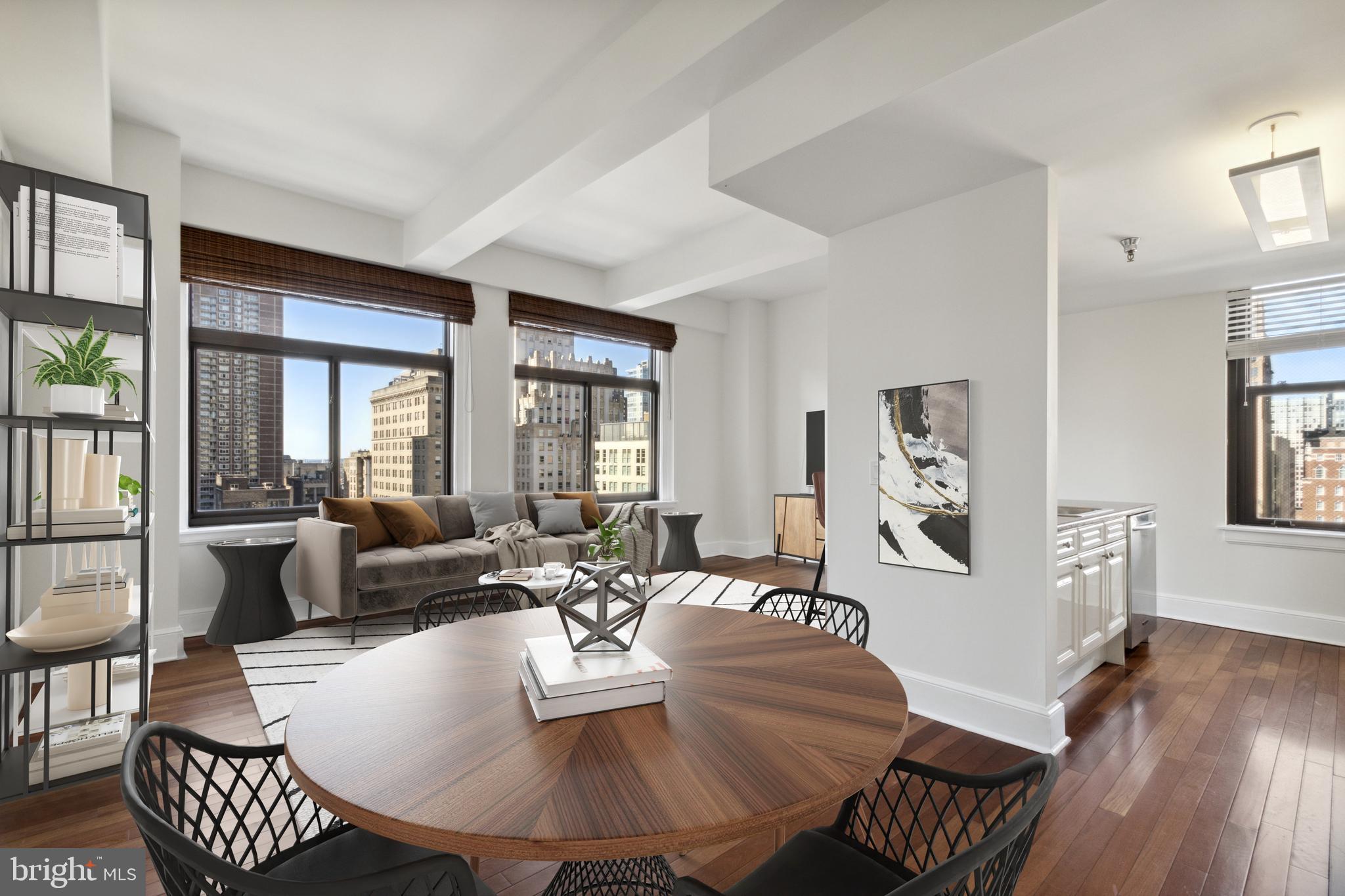 a living room with furniture a wooden floor and a large window