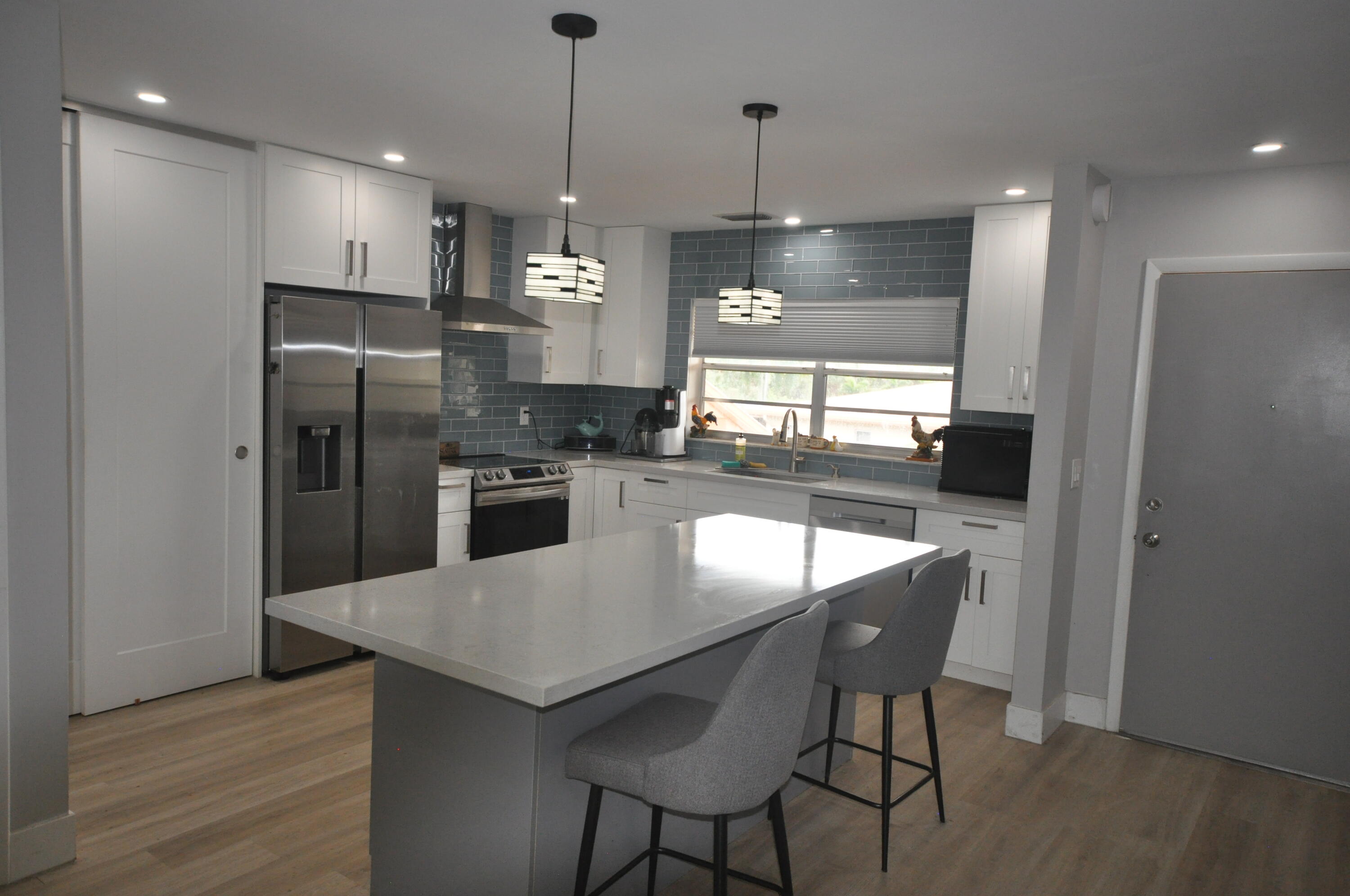 a kitchen with refrigerator and microwave