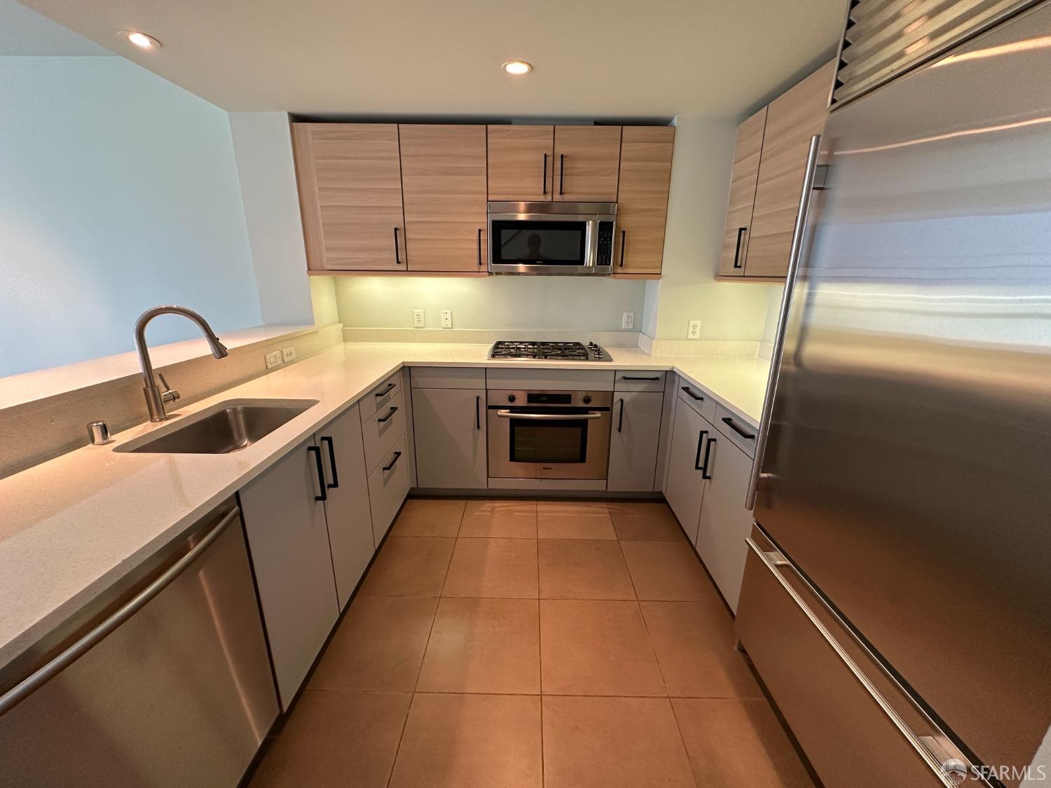 a kitchen with stainless steel appliances granite countertop a sink and a stove