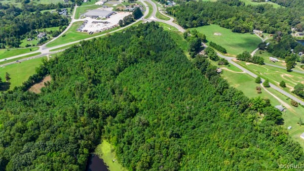 an aerial view of residential houses with outdoor space and trees all around