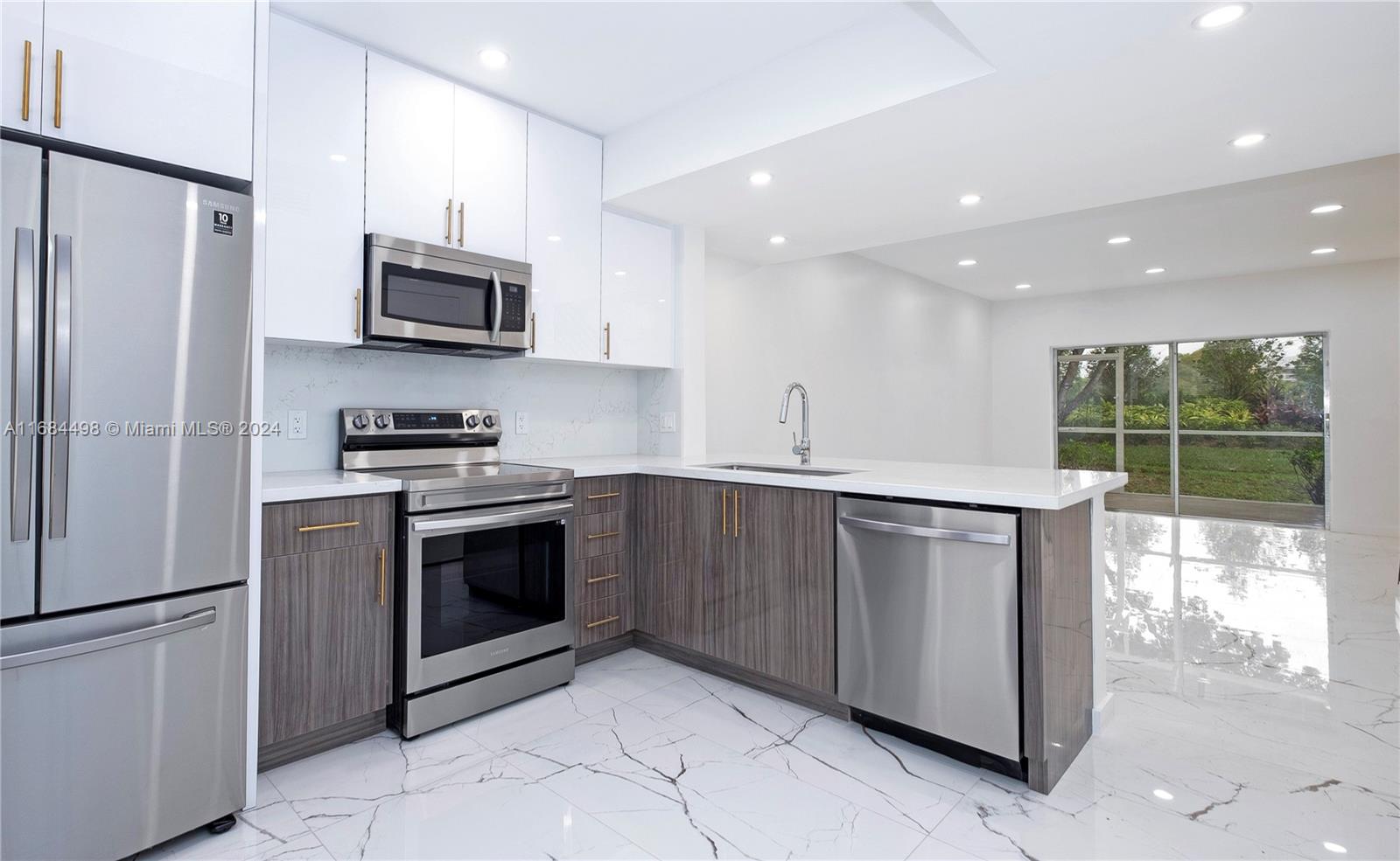 a kitchen with stainless steel appliances granite countertop a refrigerator sink and microwave