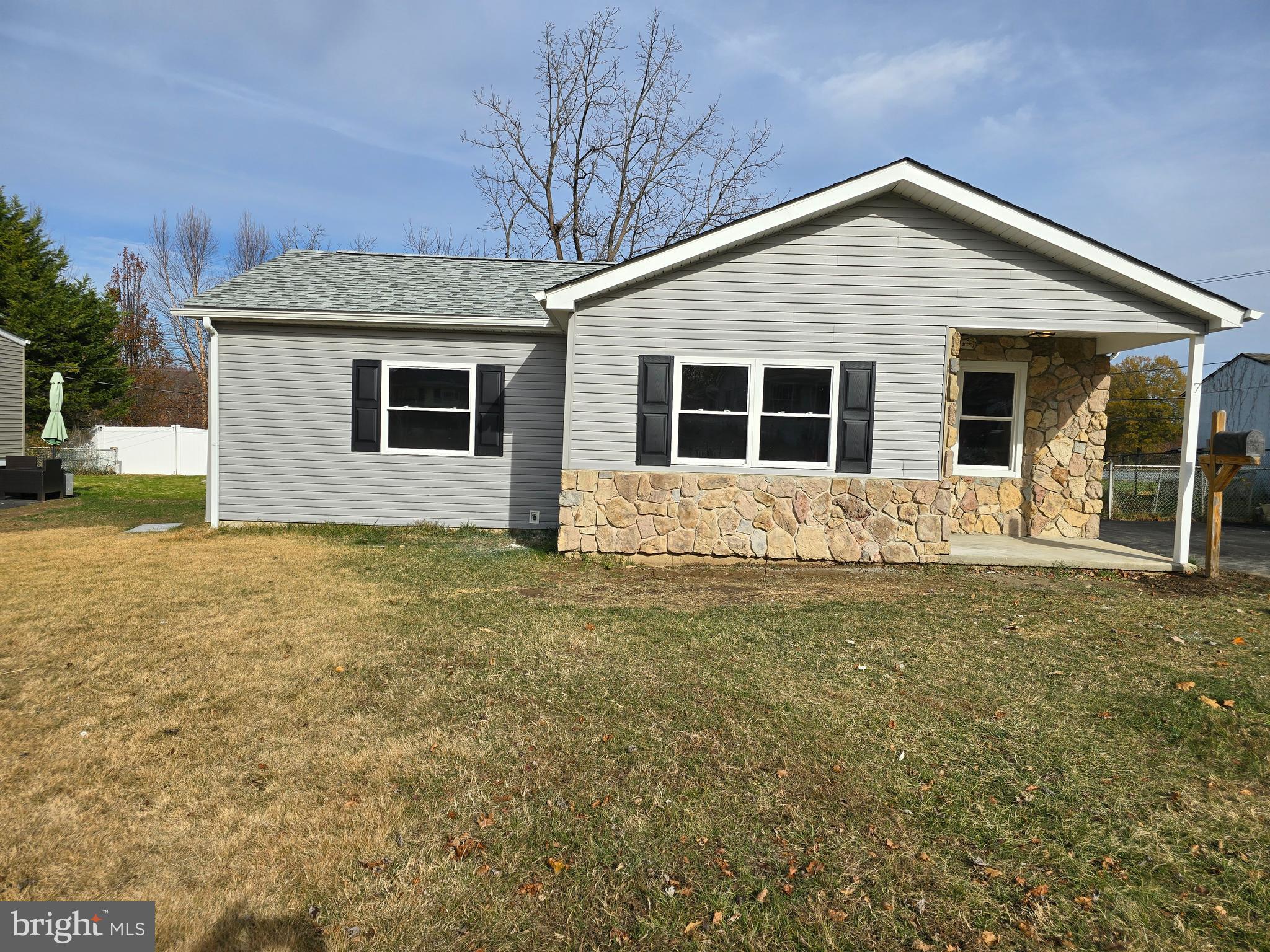 a front view of house with yard and trees around