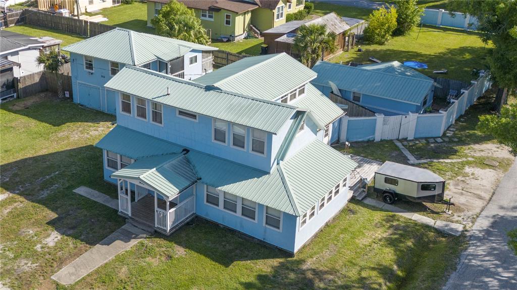 an aerial view of a house with swimming pool and large trees