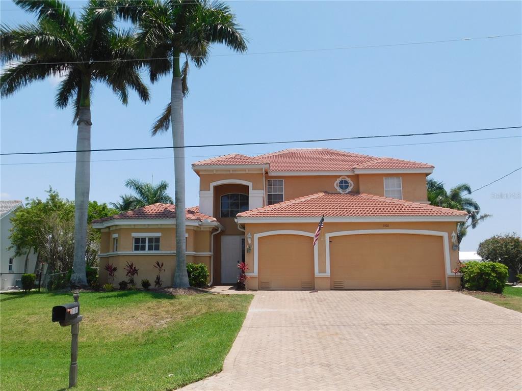 a view of a house with a yard and potted plants