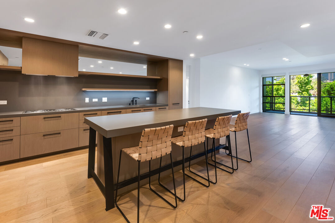 a kitchen with stainless steel appliances granite countertop table chairs sink and stove