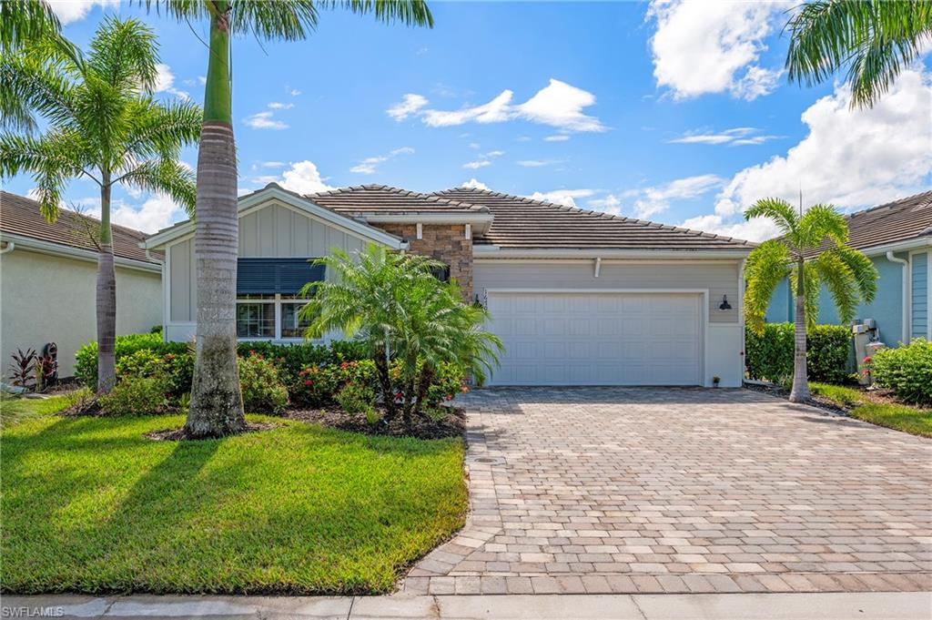 a view of a house with a small yard and palm trees