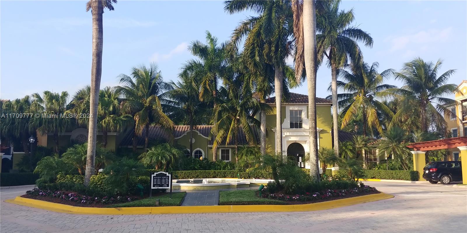 a view of a fountain with palm trees