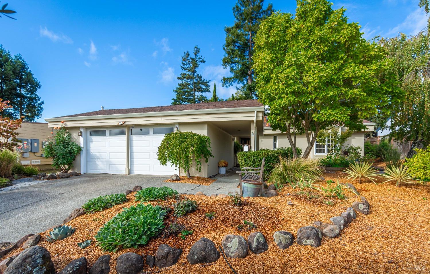 a view of a house with potted plants and large trees