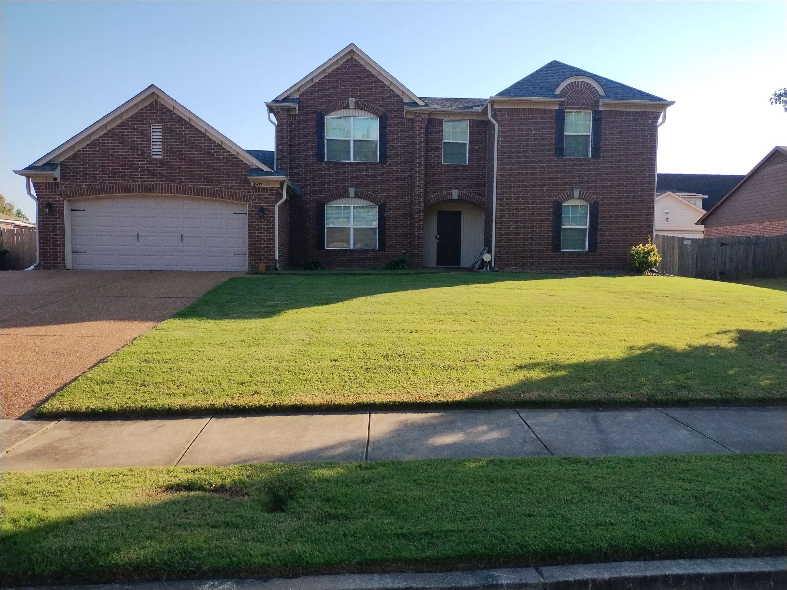 View of front of property with a garage and a front lawn