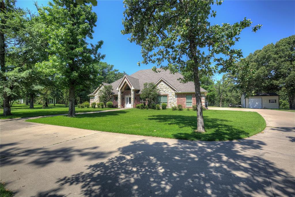 View of front of home featuring a front lawn, a garage, and an outdoor structure