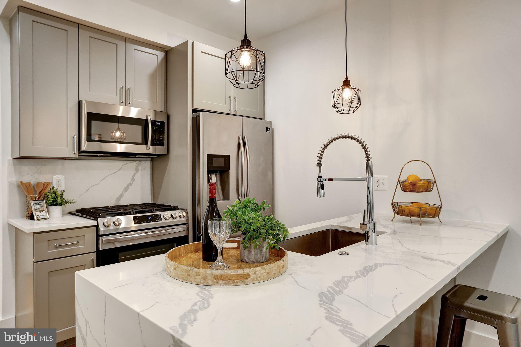 a kitchen with sink a microwave and cabinets