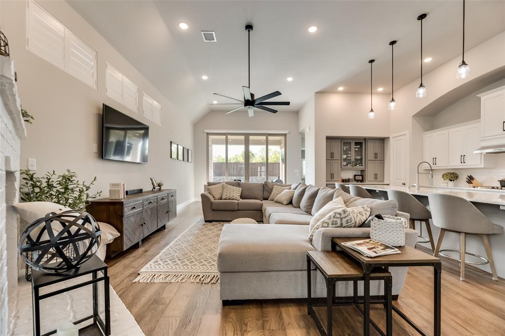 a living room with furniture a rug kitchen view and a chandelier