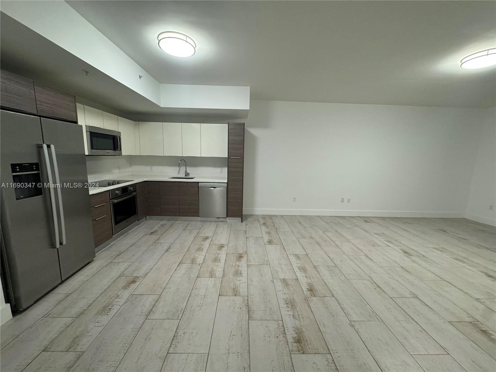 an empty room with wooden floor and window