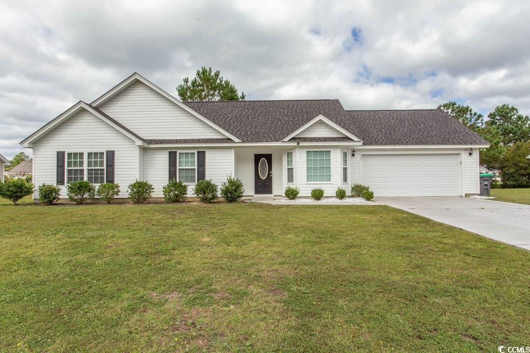 Ranch-style house featuring a garage and a front y