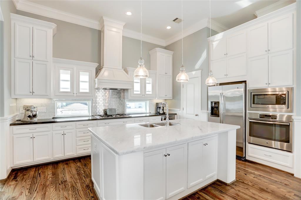 a kitchen with granite countertop a sink stainless steel appliances and cabinets