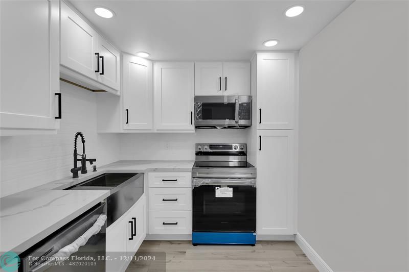 a kitchen with stainless steel appliances a sink stove and cabinets