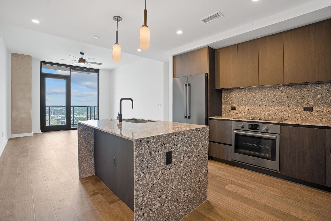 a kitchen with stainless steel appliances granite countertop a sink stove and refrigerator