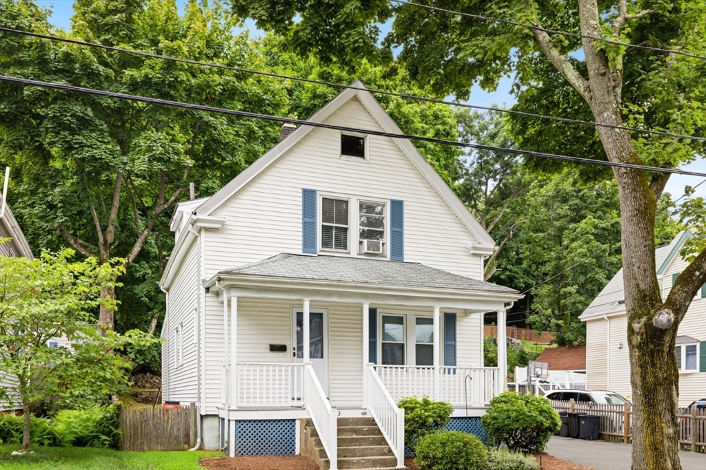 a front view of a house with a yard and trees