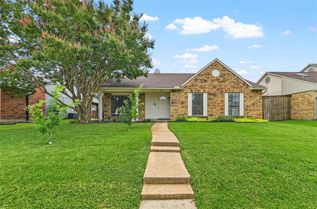 front view of a brick house with a yard