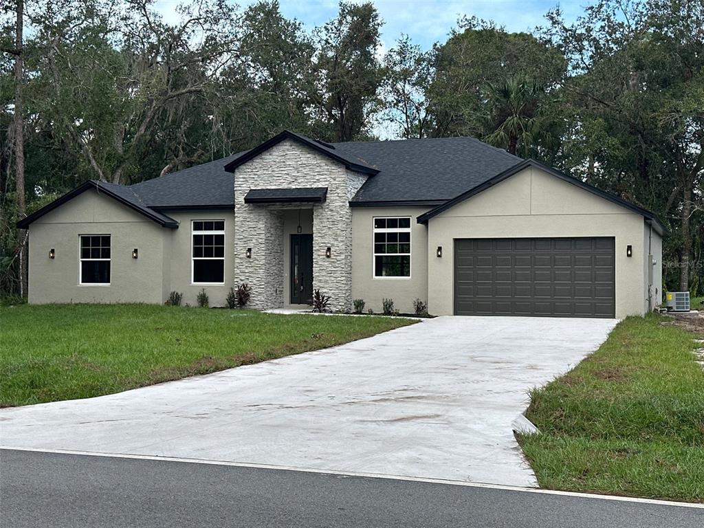 a front view of a house with a yard and garage