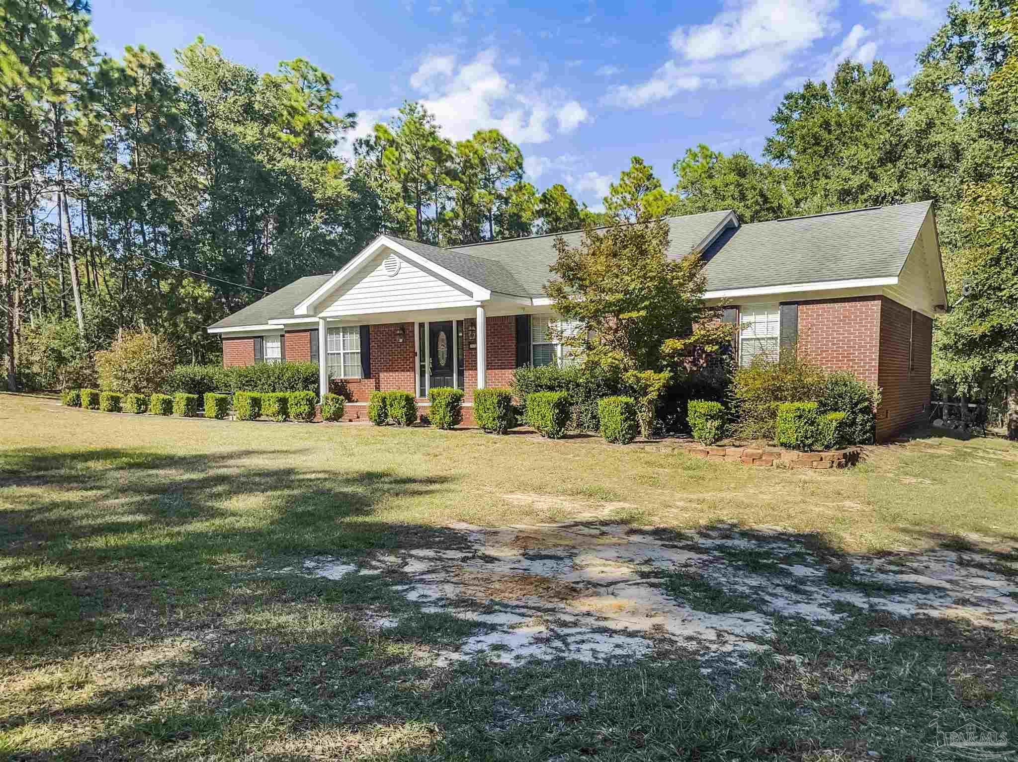 a front view of a house with a yard and lake view