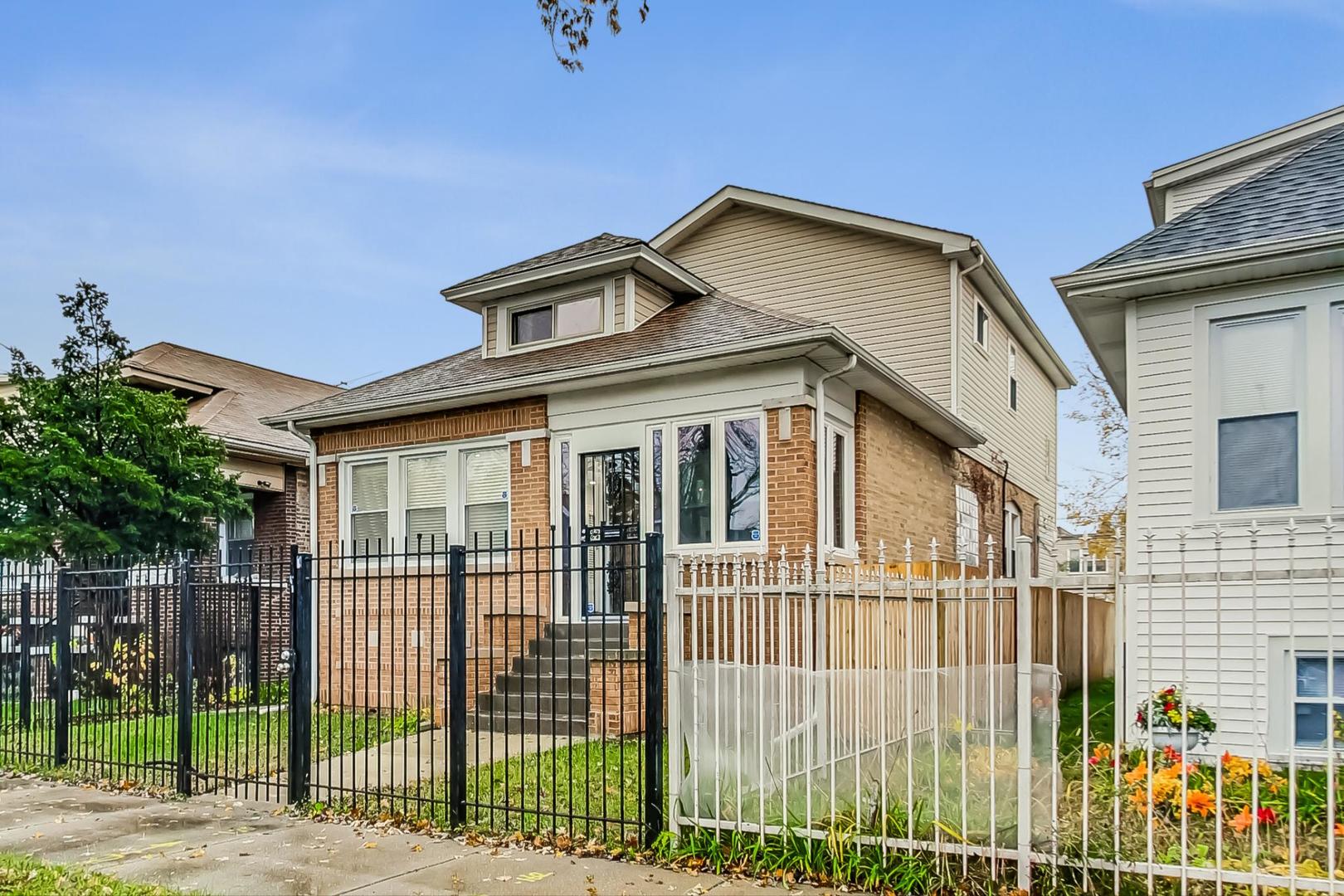 a front view of a house with a iron gate