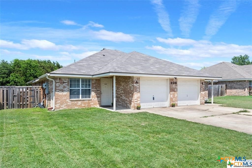 a front view of a house with a garden and yard