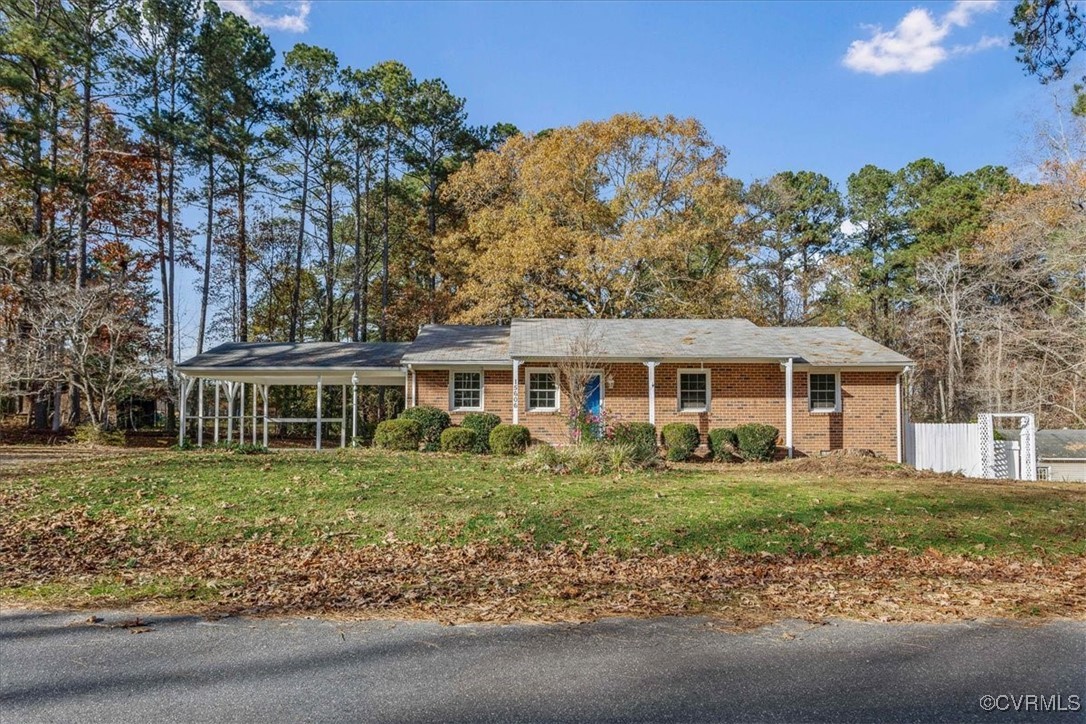 Ranch-style home featuring a front lawn and a carp