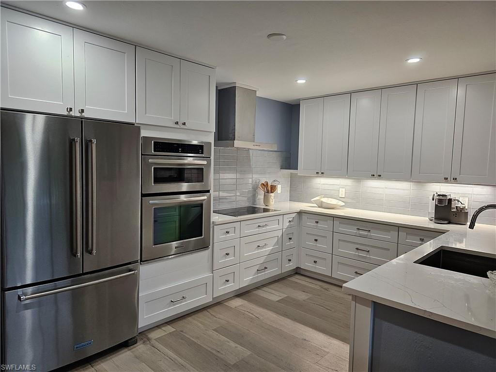 a kitchen with white cabinets and stainless steel appliances