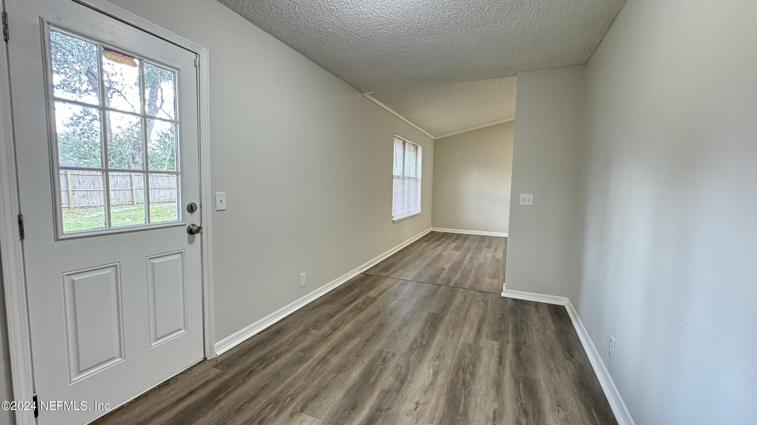 a view of a room with wooden floor and window