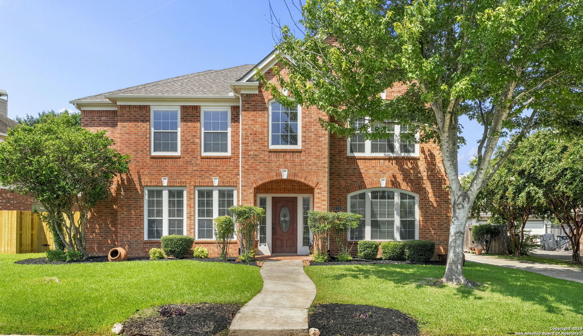 front view of a brick house with a yard