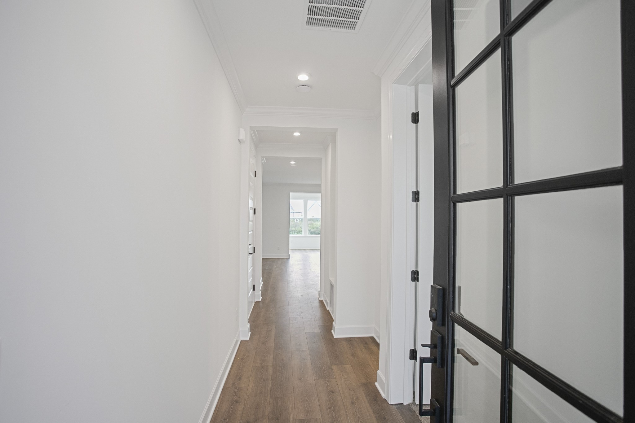 a view of a hallway with wooden floor and staircase