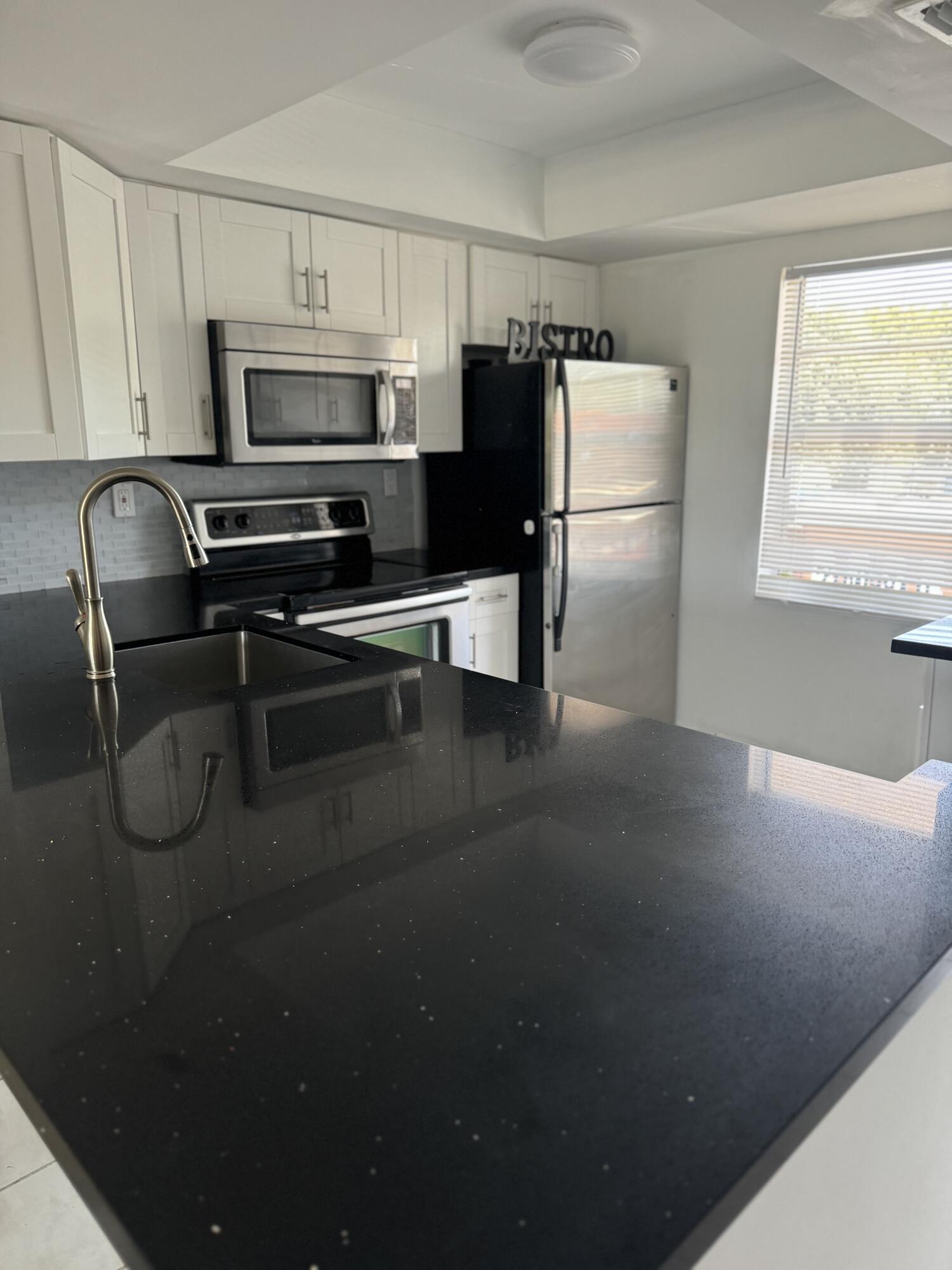 a kitchen with a refrigerator and a stove top oven