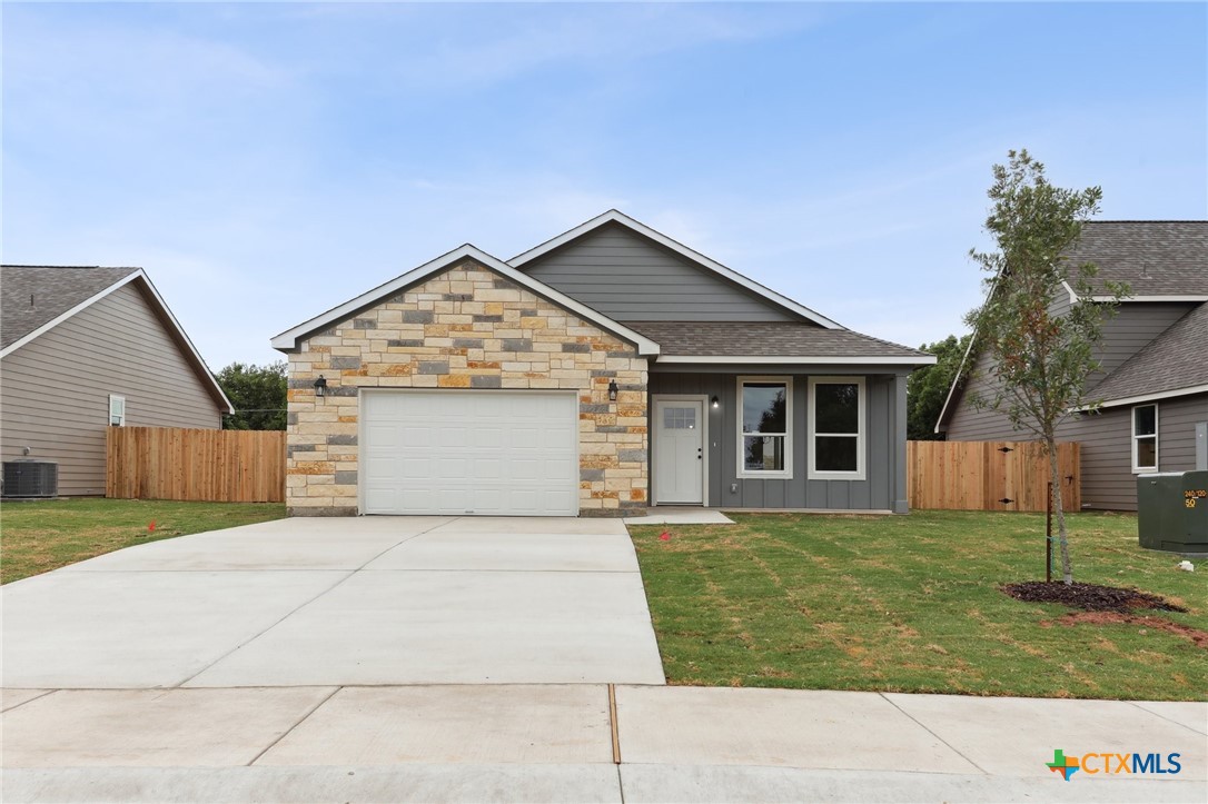 a front view of house with yard and trees in the background