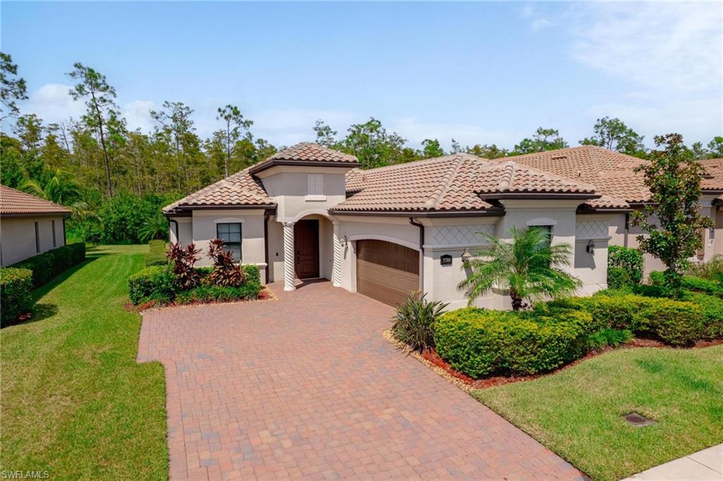 Mediterranean / spanish home featuring a front lawn and a garage