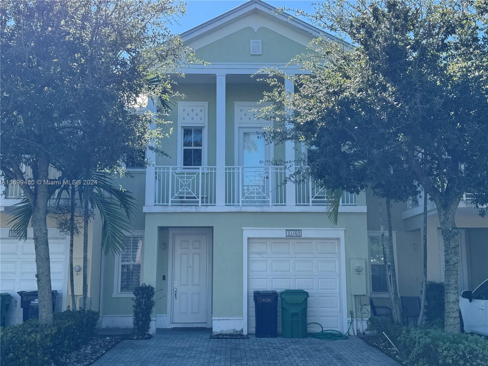 a front view of a house with plants