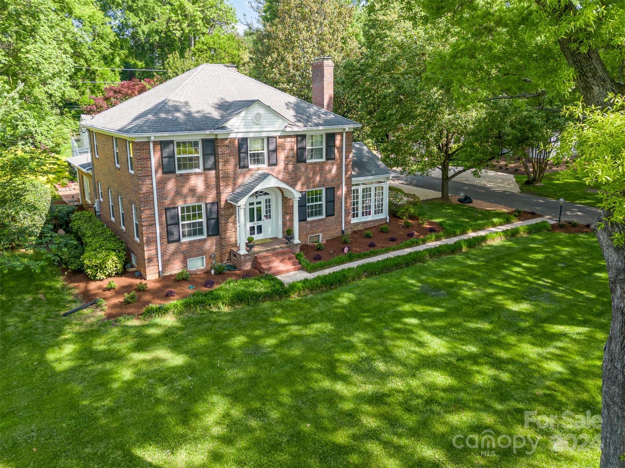 a front view of a house with a yard porch and green space