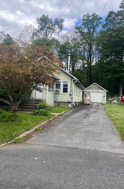 View of front of property featuring a garage and an outbuilding