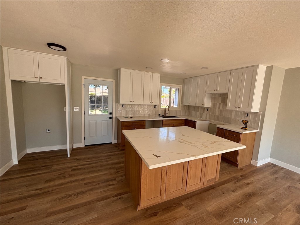 a kitchen with a refrigerator a sink and wooden cabinets