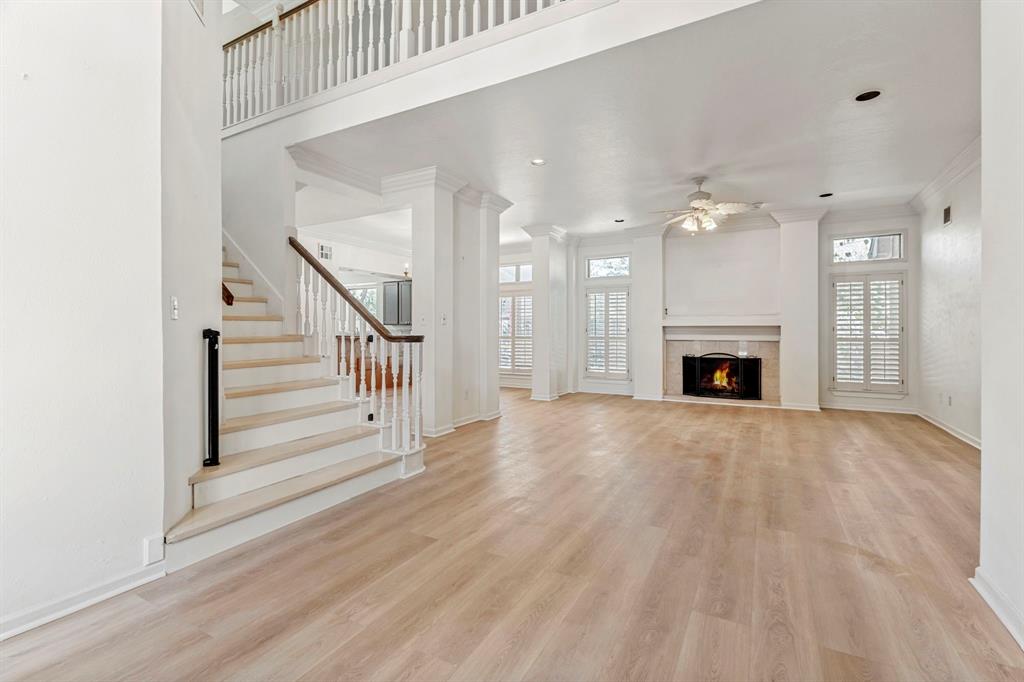 a view of empty room with wooden floor and fireplace