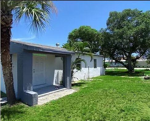 a front view of house with yard and trees