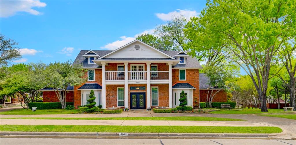 a view of a big house with a big yard and large trees