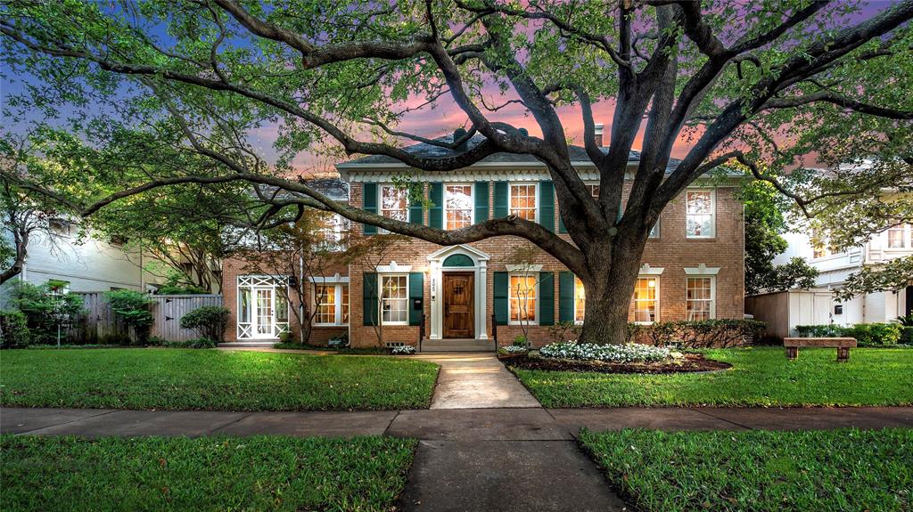 a front view of a house with a yard and potted plants