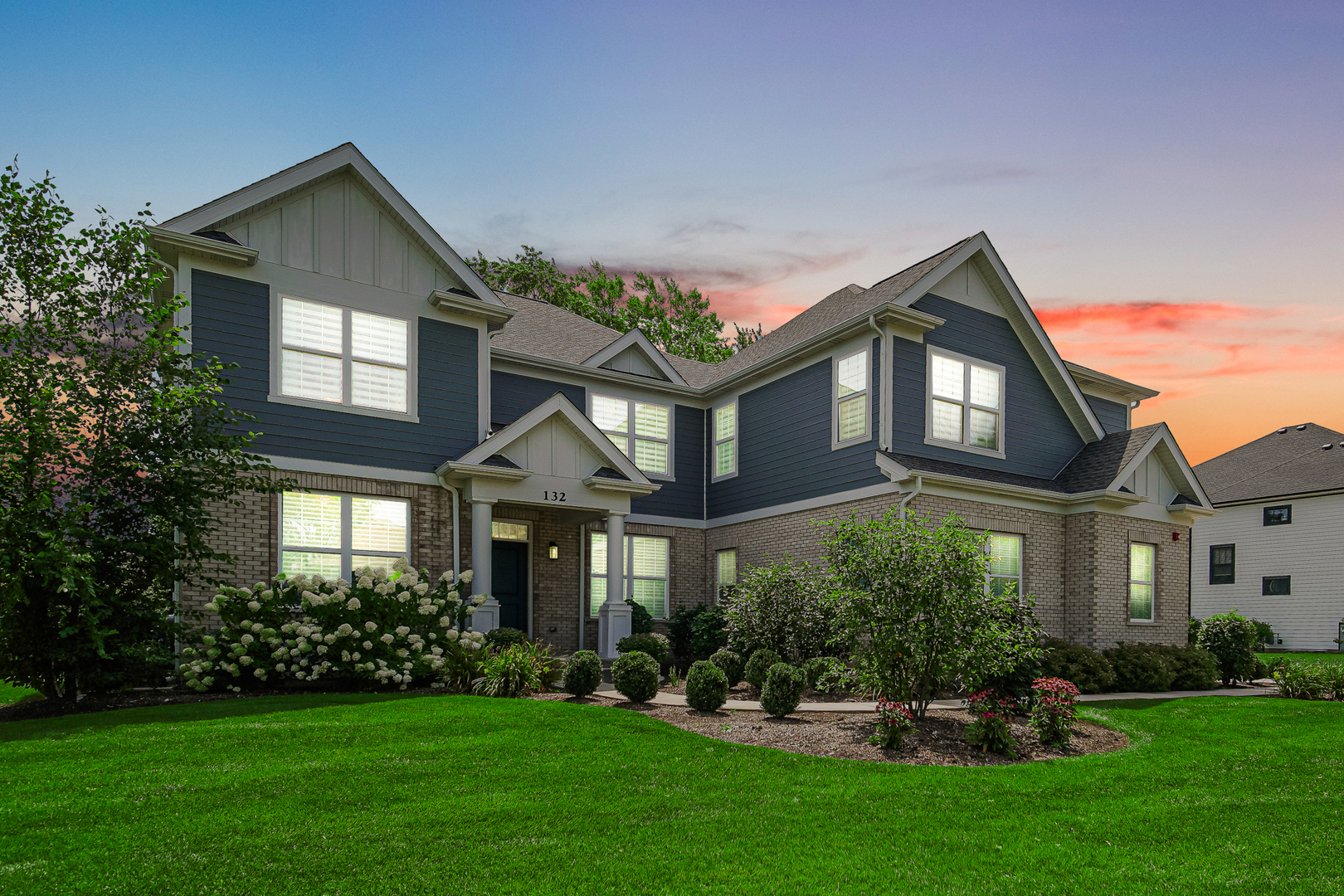 a front view of a house with a yard and trees