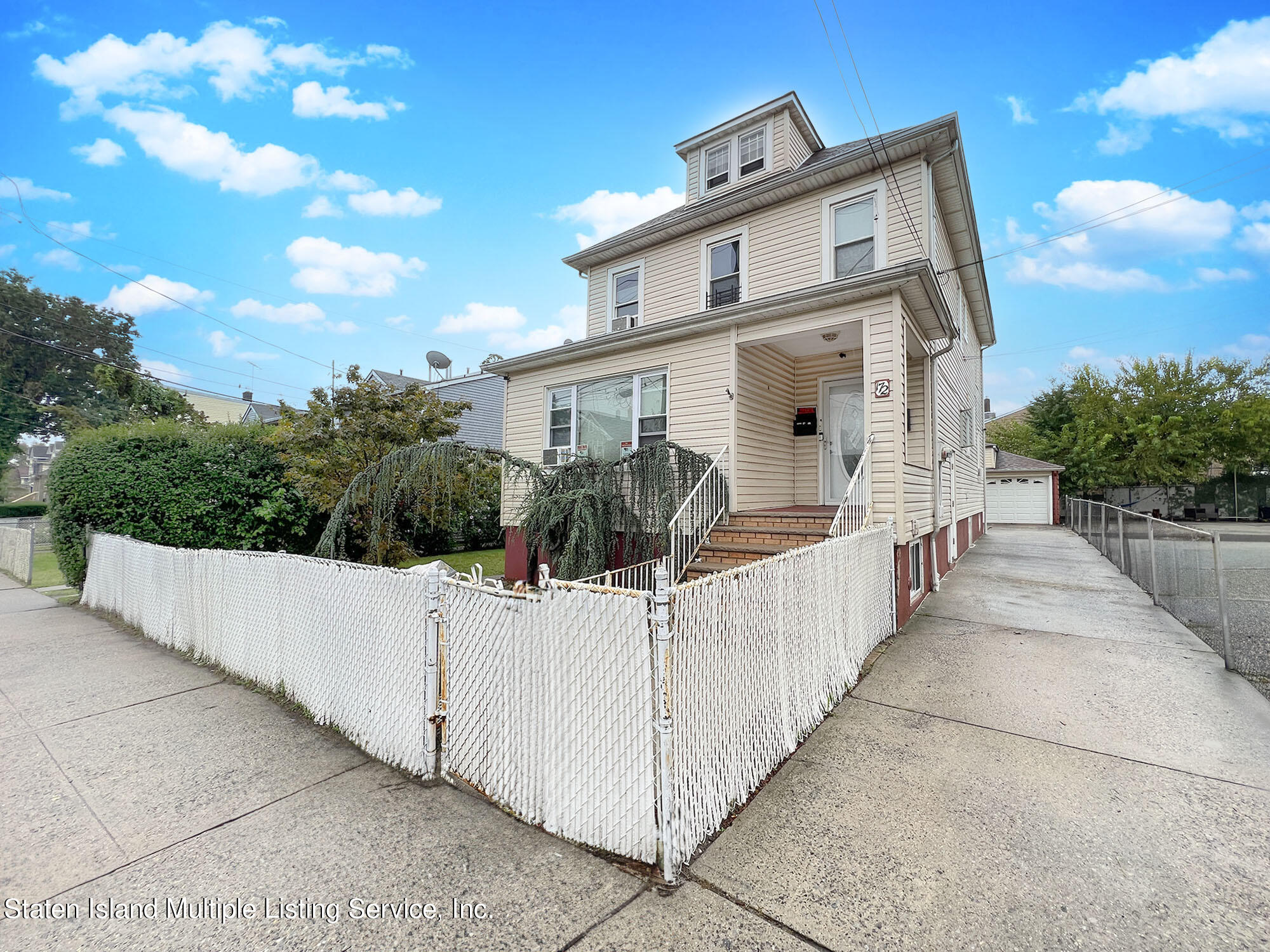 a view of a white house with wooden fence