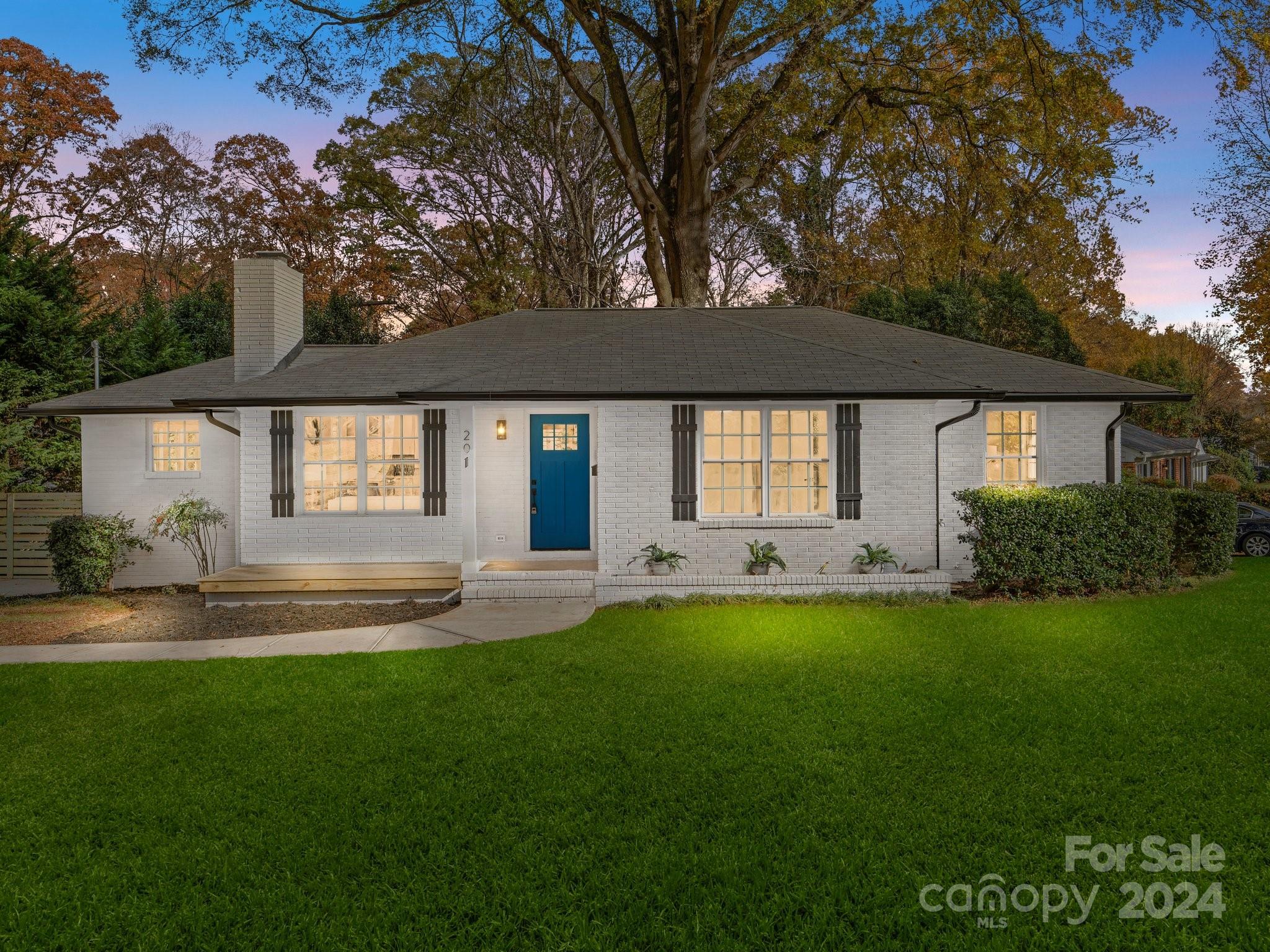 a front view of a house with a garden and yard