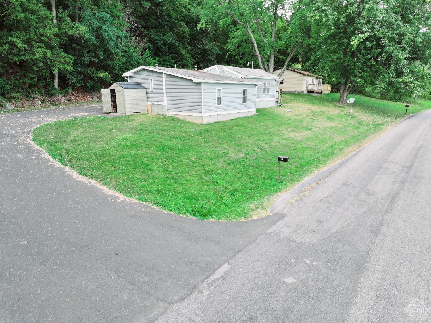 a view of a house with a yard and small garden