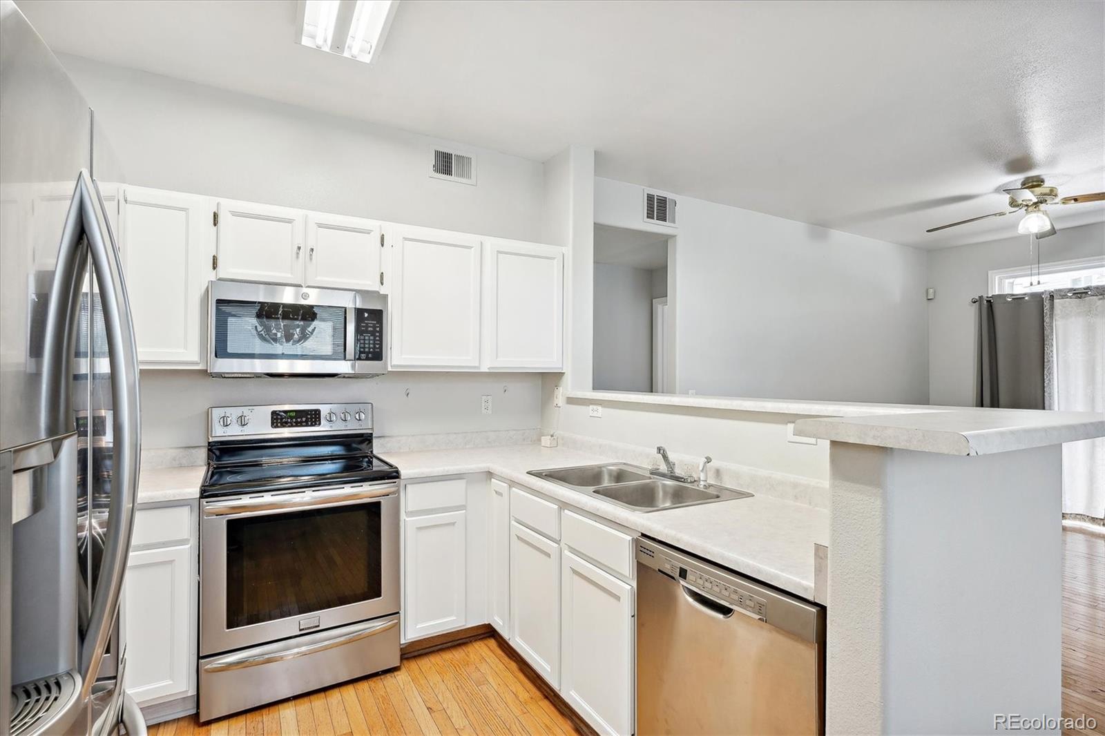 a kitchen with granite countertop white cabinets and stainless steel appliances