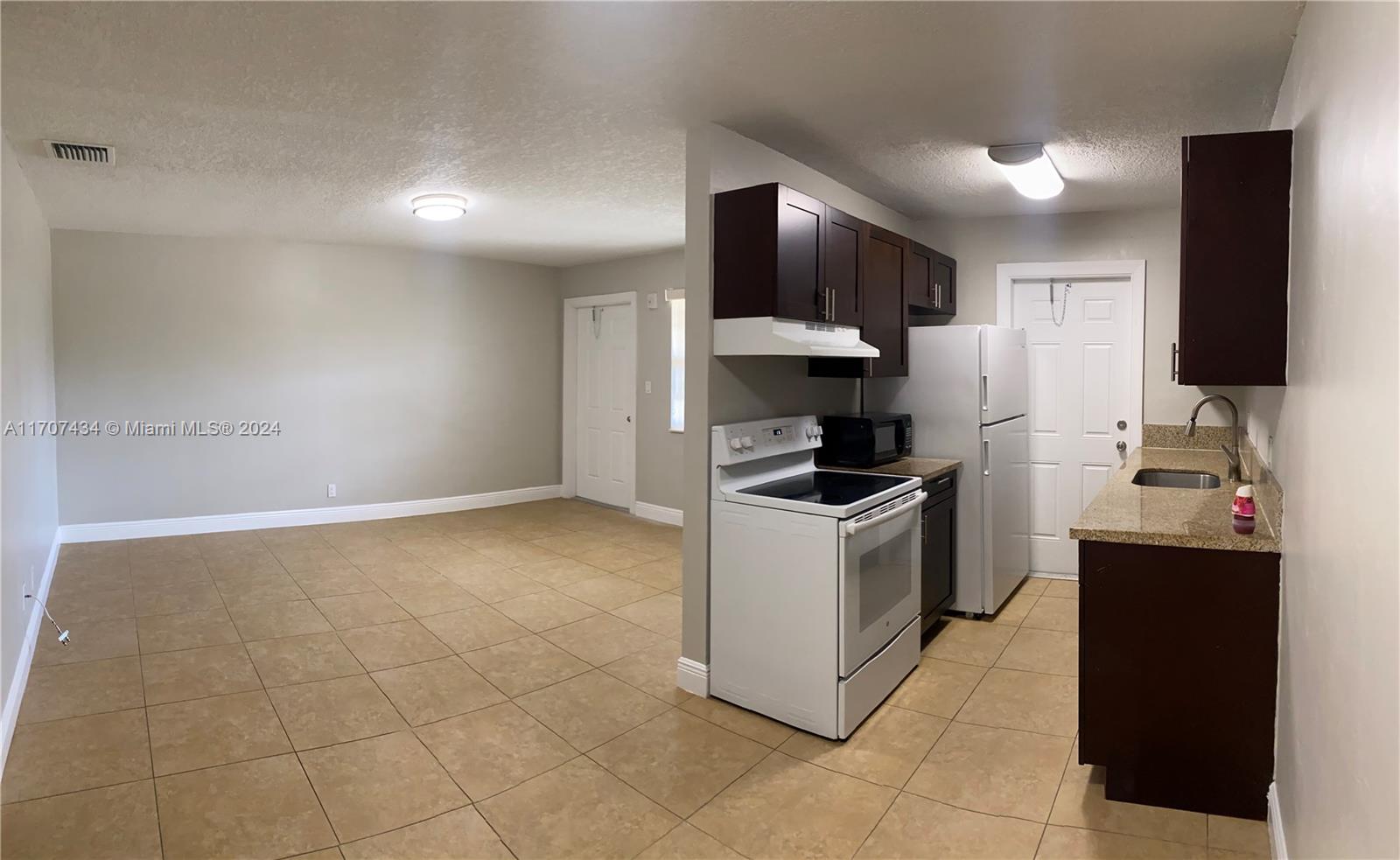 a kitchen with stainless steel appliances granite countertop a refrigerator and a stove top oven