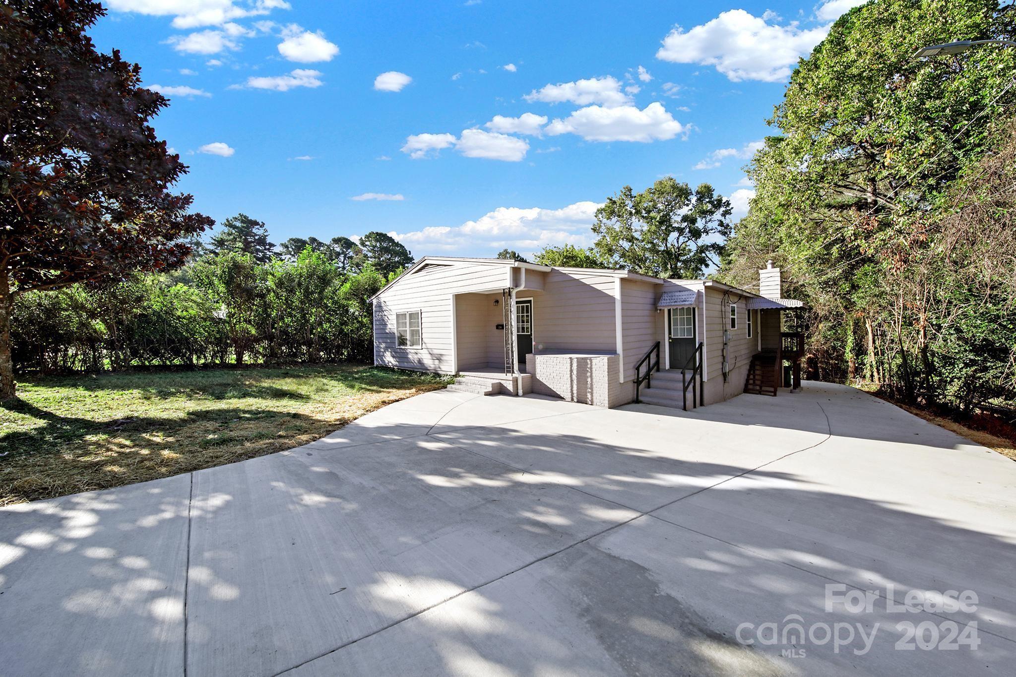 a view of a house with a yard and pathway